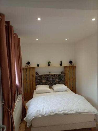 une chambre avec un grand lit avec deux oreillers dans l'établissement Appartement Chez Marcel, à Saint-Lager-Bressac