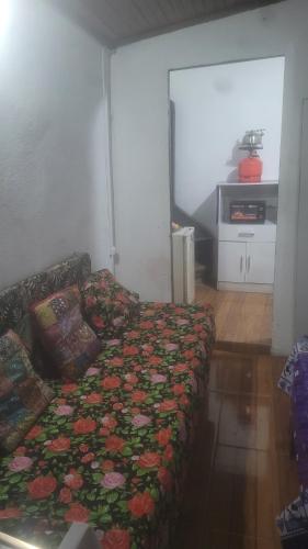- un salon avec un lit fleuri dans l'établissement casitadeplaya, à Balneario Buenos Aires