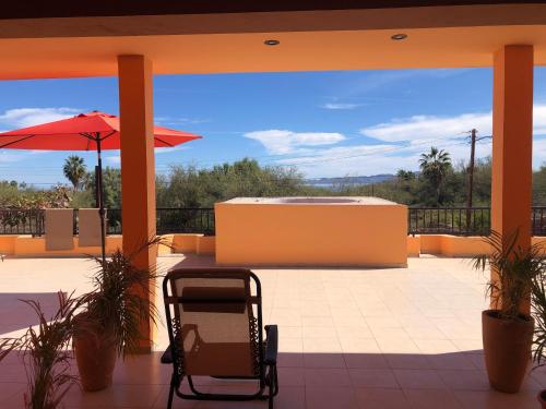 a chair on a patio with a hot tub and an umbrella at Tres Iguanas Apart Hotel - New, cozy & spacious flats, short walk to beach in Loreto
