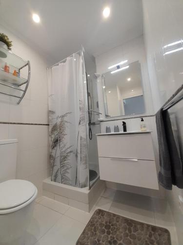 een badkamer met een douche, een toilet en een wastafel bij Luxury private apartment at the beach in a 4 star hotel first beach line in Fuengirola