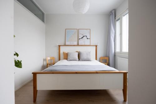 a bedroom with a bed in a white room at Ydinkeskustan designkaksio in Hämeenlinna