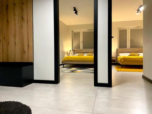 a bedroom with two beds and two mirrors at Apartament Twierdza z widokiem na jezioro in Ostróda
