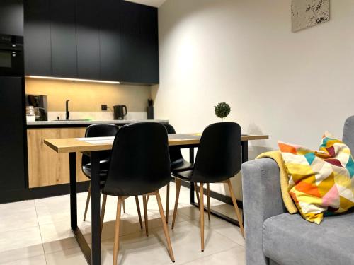 een keuken en eetkamer met een tafel en stoelen bij Apartament Twierdza z widokiem na jezioro in Ostróda