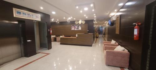 a lobby with a waiting room with couches and clocks at مهاد للشقق المخدومه in Najran