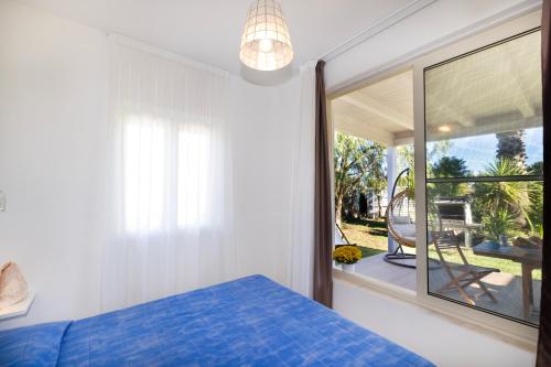 a bedroom with a blue bed and a window at Aria di Mare Vieste - Luxury Apartments by the Sea in Vieste