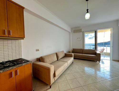a living room with a couch and a kitchen at Fane's Apartments in Himare