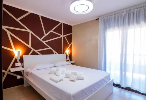 1 dormitorio con cama blanca y ventana en Ninel Home Tenerife, en Palm-mar