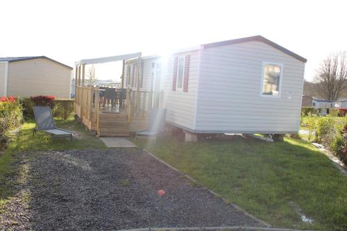 a white tiny house in a yard with a patio at Mobil-home in Litteau