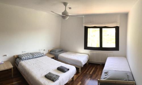 1 dormitorio con 2 camas y ventana en Lar do Pazo, en Barro