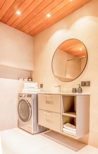 a washer and dryer in a bathroom with a mirror at City Panorama with SAUNA in Tartu