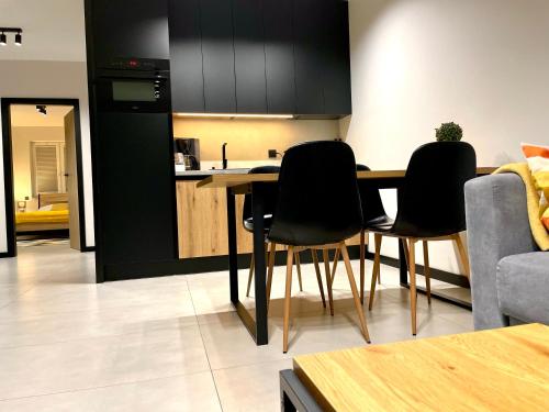 a kitchen with a table and chairs in a room at Apartament Twierdza przy plaży ROYAL APARTS OSTRÓDA in Ostróda