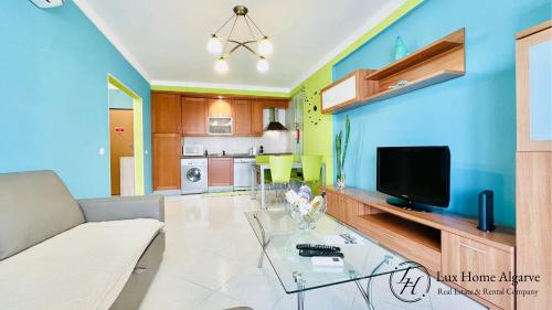 ein Wohnzimmer mit einem Sofa und einem TV in der Unterkunft Alegria - Shopping Center 150m - Pool - Parking - Terrace in Portimão