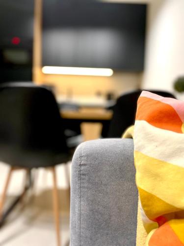 a colorful pillow sitting on the back of a chair at Apartament Twierdza przy plaży ROYAL APARTS OSTRÓDA in Ostróda
