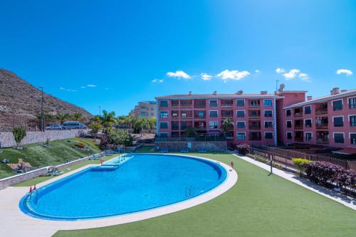 a large swimming pool in front of a building at Ninel Home Tenerife in Palm-mar