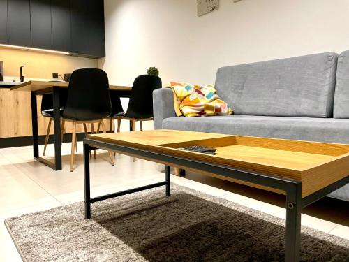 a living room with a couch and a coffee table at Apartament Twierdza przy plaży ROYAL APARTS OSTRÓDA in Ostróda