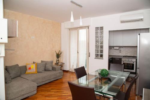 ein Wohnzimmer mit einem Sofa und einem Glastisch in der Unterkunft LA CASA DI AMBRA in Limbiate
