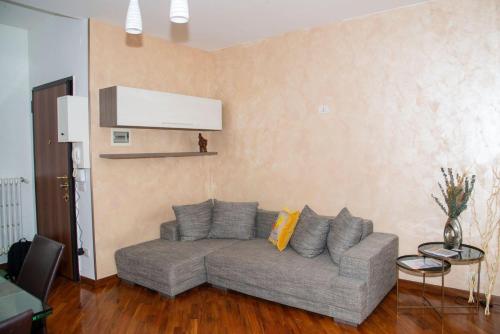 a living room with a gray couch in a room at LA CASA DI AMBRA in Limbiate