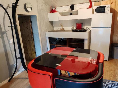 une petite cuisine avec une table et un réfrigérateur dans l'établissement ex domaine Chandelier maison, à Anglade