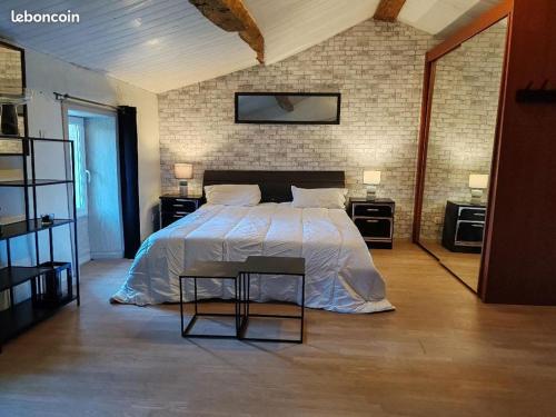 une chambre avec un grand lit avec deux tables de nuit dans l'établissement ex domaine Chandelier maison, à Anglade