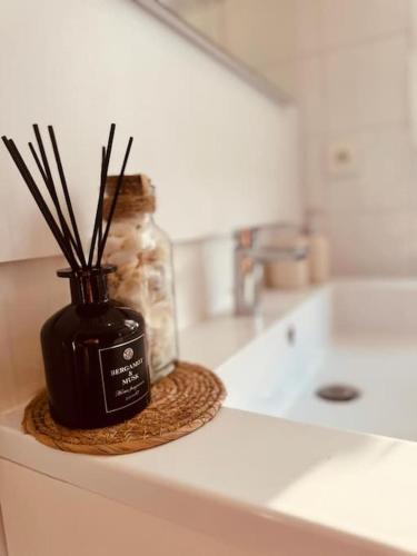 un vase avec des bâtons assis sur un comptoir dans l'établissement L'escale Versailles paris G/W/N, à Versailles