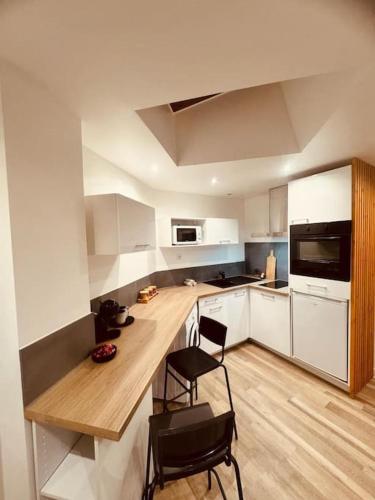 - une cuisine avec une table et deux chaises dans l'établissement L'escale Versailles paris G/W/N, à Versailles