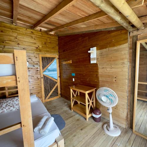 a bedroom of a log cabin with a bed and a desk at Hostel Santa Cruz del Islote in Santa Cruz del Islote