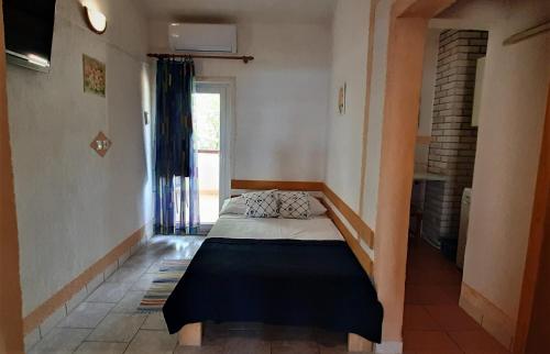 a bedroom with a bed in a room with a window at Apartments Vila Zagorje in Stinica