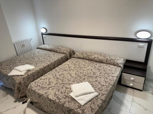 um quarto com 2 camas e toalhas em Jcube Apartments Bocconi Milano em Milão