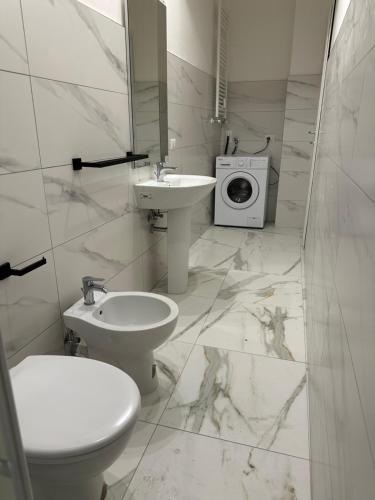 uma casa de banho com um lavatório e uma máquina de lavar roupa em Jcube Apartments Bocconi Milano em Milão