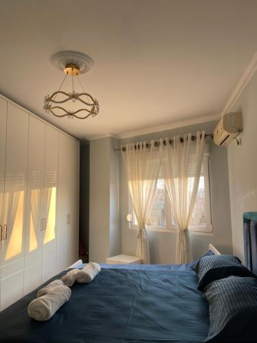 Un dormitorio con una cama azul con toallas. en Besa Apartment en Tirana