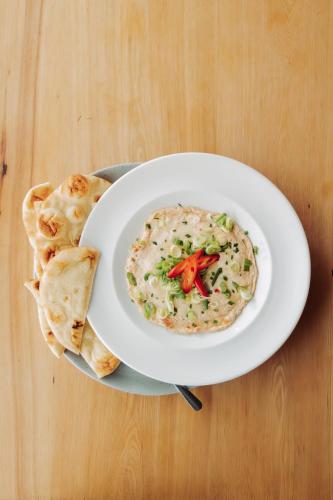 a plate with a bowl of dip and pita bread at Penny's Motel in Thornbury