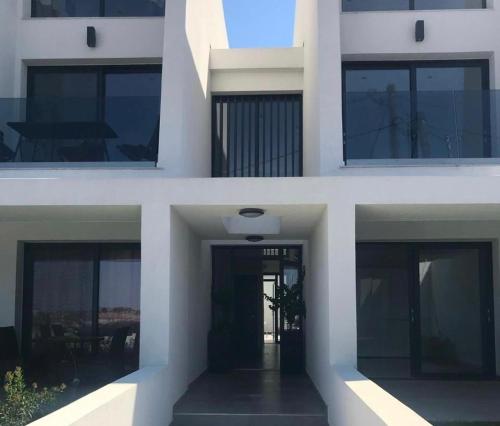 trzy różne widoki na biały budynek z oknami w obiekcie Kallithea love paradise pool & garden w mieście Kallithea