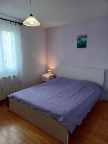 sypialnia z łóżkiem z fioletowym kocem w obiekcie Lavanda w miejscowości Mali Lošinj