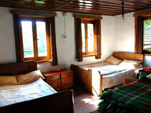 a room with two beds and a couch and windows at Guest House Four Pines in Beli Osŭm