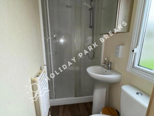 a bathroom with a shower and a sink and a toilet at Aloha - Cosy 2 Bed Close to Venue at Seal Bay, Selsey in Chichester