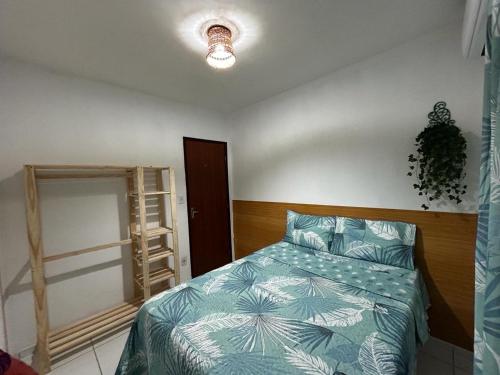 a bedroom with a bed with a green comforter at Apto bem localizado est de Ribamar ao lado do shopping in São-José-do-Ribamar