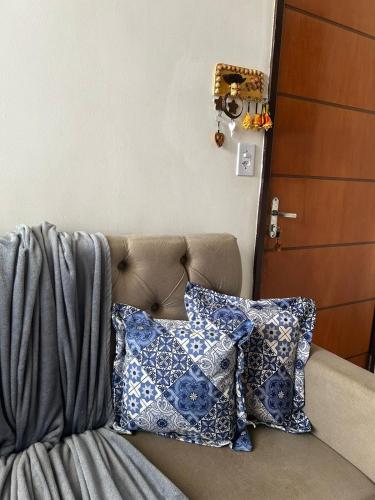 a couch with pillows on it next to a door at Apto bem localizado est de Ribamar ao lado do shopping in São-José-do-Ribamar