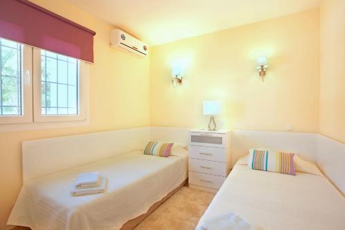 1 dormitorio con 2 camas y ventana en Casa Progreso Costabella, en Marbella