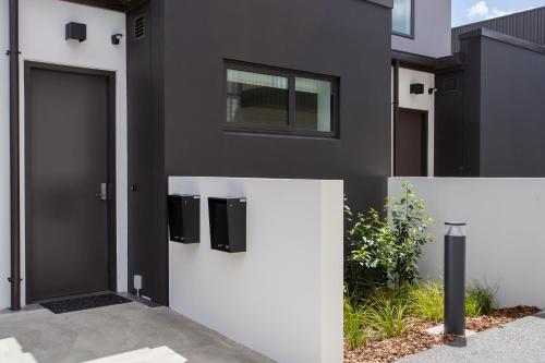 a black and white house with a door at Location Location Location 2 Mins CBD Free Parking in Christchurch