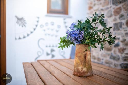 a vase filled with purple flowers sitting on a table at SKINOS rooms and apartment in Pyrgi