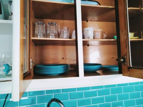 einen Küchenschrank mit blauem Geschirr darin in der Unterkunft DORIS Beach House. Praia Furadouro .Ovar.Aveiro in Furadouro