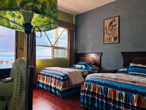a bedroom with two beds and a window at Ribiera del Lago Peten Itza in Flores