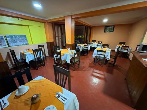 an empty dining room with tables and chairs with yellow tables at HOSTAl HUAYNA HOUSE in Cusco