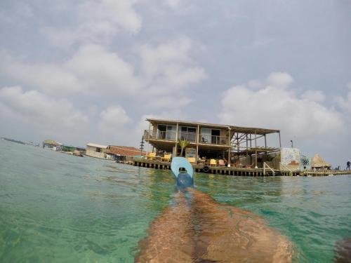 una persona en el agua con un barco en el agua en Hostel Santa Cruz del Islote, en Santa Cruz del Islote