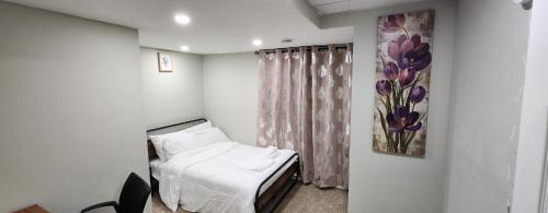 New Stylish 2-Bedroom Basement Suite في وينيبيغ: غرفة مستشفى بسرير ولوحة على الحائط