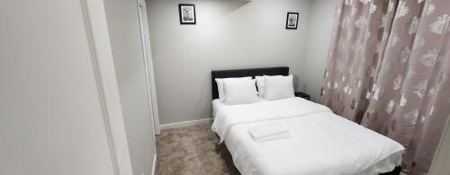 a bedroom with two beds with white sheets and pillows at New Stylish 2-Bedroom Basement Suite in Winnipeg
