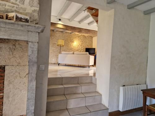 a living room with a fireplace and a white couch at Gite les Frênes avec pré dans joli hameau in Vermenton