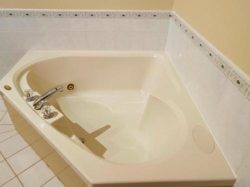 bañera blanca con grifo en el baño en Ceilidh Country Lodge, en Baddeck
