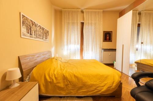 a bedroom with a bed with a yellow blanket at Casa Gozza in Verzuolo