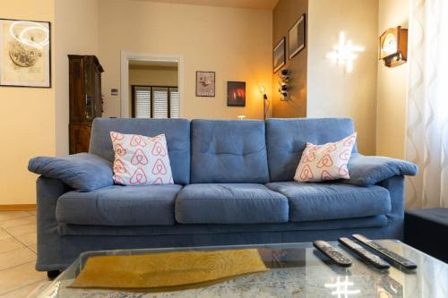 a blue couch in a living room with a glass table at Casa Gozza in Verzuolo